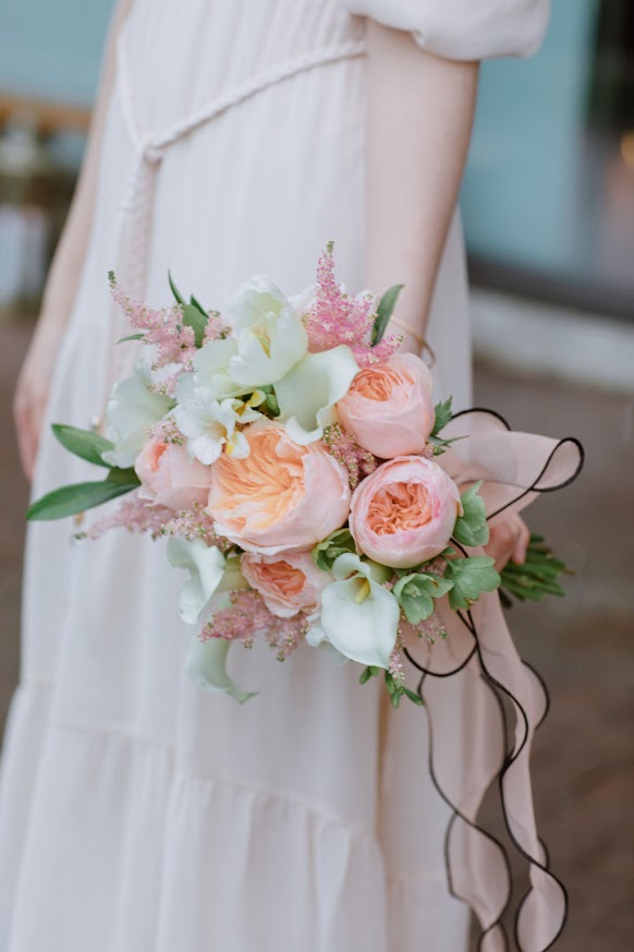 A girl holding a bridal bouquet with 51 pink flowers by La Rose Fleur